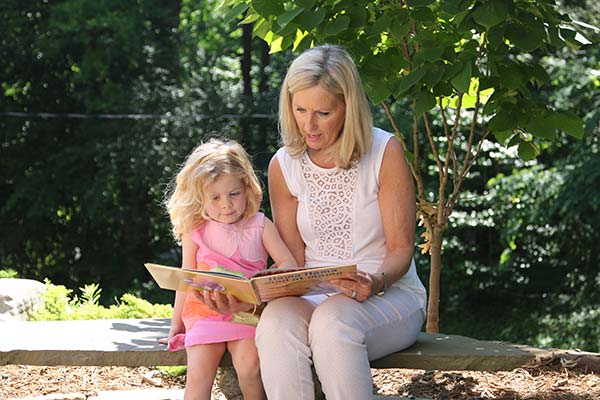 Teacher reading with child outdoors